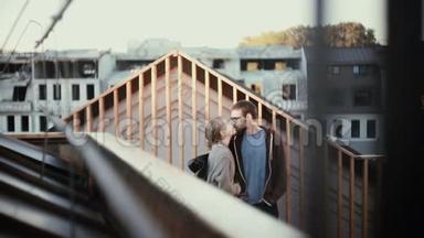 年轻的幸福夫妇站在屋顶上欣赏美丽的景色。 迷人的<strong>男人</strong>和女人在上面<strong>接吻</strong>。