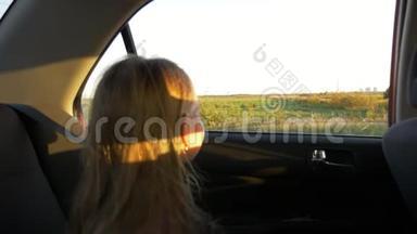 年轻的白种人女孩坐车。 慢动作。 聚焦到车外，窗外，田野和农村的场景。 秋日日落