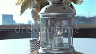 美丽的白色烛台特写.. 录像。 在玻璃烛台上点燃蜡烛，花瓶和瓶子里放着花束