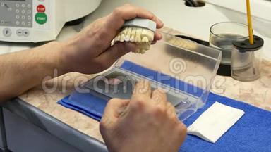 牙科技师在牙齿假体上绘制白色陶瓷釉