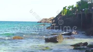 海浪飞溅在石滩和岩石岛上。 海浪在海洋的岩石海滩上破碎。 蓝色海水和大海水