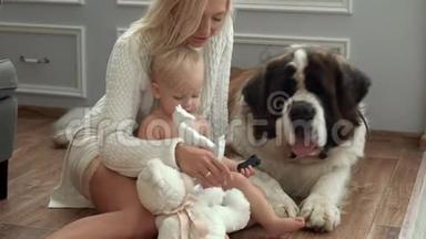 可爱的一家人和他们的狗在家里客厅的地毯上一起在沙发上放松。 妈妈和儿子一起玩
