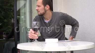 英俊的男人手里拿着杂志喝着一杯<strong>好酒</strong>。