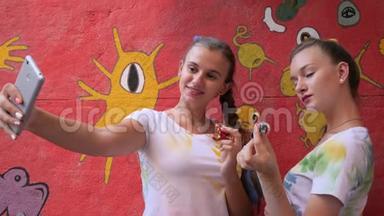 在涂鸦背景下抱着旋转体的女孩塞尔菲，女朋友用玩具在手机上拍照以缓解压力