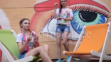 时尚女朋友在涂鸦的背景上展示与旋转的技巧，青少年旋转玩具以<strong>缓解压力</strong>。