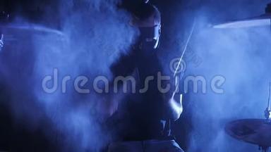 这部带有男鼓手面具的史诗镜头被烟雾围绕，在一个缓慢运动的鼓上演奏。 音乐剧