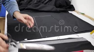 服装生产技术，专业服装设计师手中的剪刀在工作场所切割组织