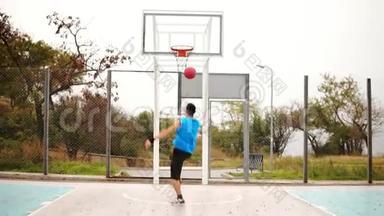 后视<strong>年轻人打篮球</strong>，并成功地向篮筐投掷一个球。 慢镜头