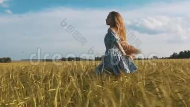美丽的健康女人穿着深色连衣裙，上面印着花，然后跑过绿色的田野，回头看，风
