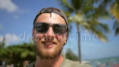 在海滩上的智能手机上，年轻的大胡子牛仔<strong>视频</strong>聊天。 在手机上聊天和做自拍。 高清<strong>慢镜头</strong>