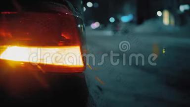 在夜间道路城市移动汽车的背景上的紧急汽车警告灯。 冬季道路交通车辆故障