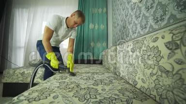 一个清洁公司的人在打扫沙发。 男士统一沙发清洁布配干蒸汽清洁剂..