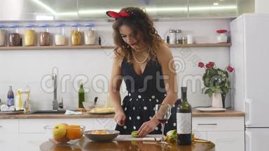 女人在家庭厨房的木制厨房板上切<strong>奇异果</strong>。 在家做饭。 厨房里的家庭气氛