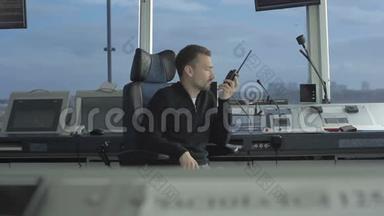 专业调度员在机场控制塔内使用便携式无线电讲话