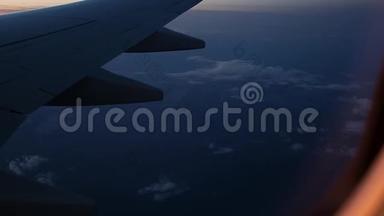 日落时从飞机窗外眺望机翼的景色。