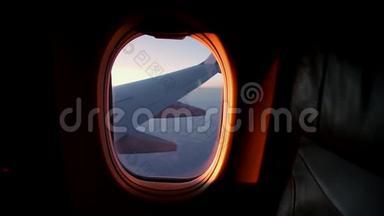 日落时从飞机窗外眺望机翼的景色。