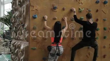 男人和女人在室内运动俱乐部用石头爬墙。