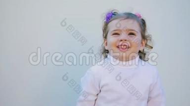 一个可爱的小宝宝正看着相机，在白色的背景上微笑。
