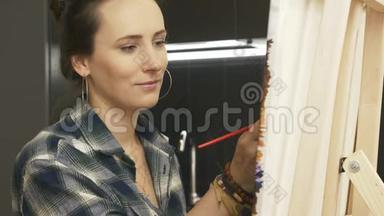 微笑的女人在家厨房里画画。 年轻有才华的女艺术家用丙烯酸颜料在画布上画画。 <strong>止痛药</strong>