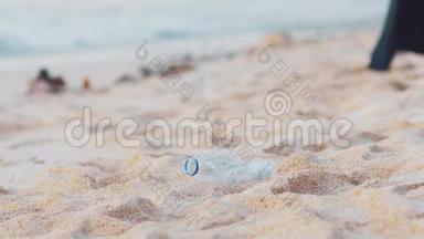 特写志愿者在白色的海洋海滩上捡起塑料瓶。 志愿者打扫海滩。 整理一下