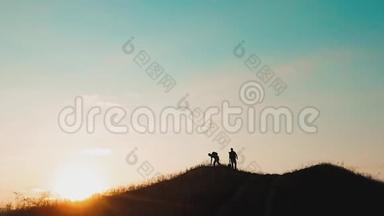 两个男游客徒步者剪影去山日落旅游慢动作视频.. 旅行成功的年轻人