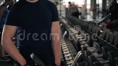 有哑铃的年轻人准备在健身房锻炼肌肉，做运动的强壮运动员准备做运动