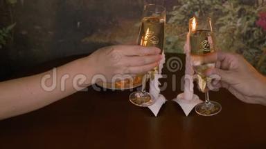 刚<strong>结婚</strong>的新婚夫妇戴着眼镜。 在桌子上烧<strong>蜡烛</strong>。 男女手举起一杯