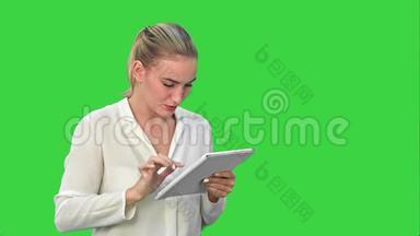 女商人站在数字平板电脑上，触摸<strong>屏幕</strong>，在<strong>绿</strong>色<strong>屏幕</strong>上微笑，Chroma键。