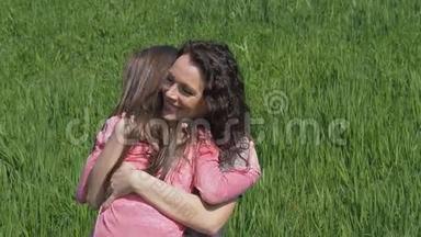 妈妈在大自然中拥抱孩子.. 在<strong>草地上</strong>的公园里有<strong>小女孩</strong>的女人。 家人在草坪<strong>上</strong>拥抱。
