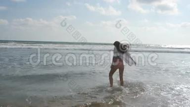 年轻漂亮的女孩在海边享受生活和乐趣。快乐的女人站在海边