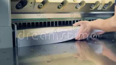 工人把纸放入剪纸工业机器。4公里。