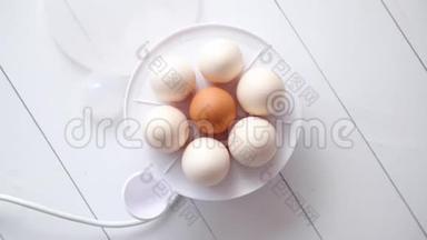 放在白色木桌上的鸡蛋电饭锅里的鸡蛋