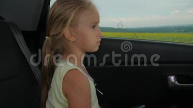 小女孩，无聊的在车里看着窗外..