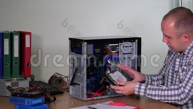 年轻的维修工在电脑中心将硬盘安装到台式电脑机箱中
