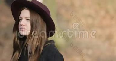 迷人的年轻女孩留着长发，秋天的外套和紫色的帽子在公园里散步，斯泰迪卡姆射击，4K，近距离。