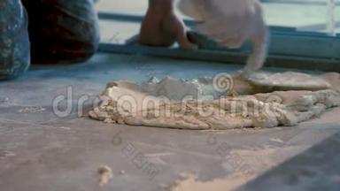 在铺设瓷砖之前，工人将水泥胶和瓷砖胶粘剂<strong>放在地板</strong>上