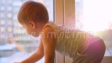 一个孩子用缓慢的动作透过阳光望着窗外