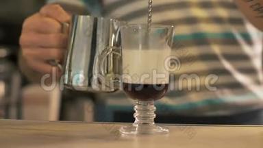 咖啡厅咖啡师在咖啡杯中倒牛奶，准备咖啡店的拿铁