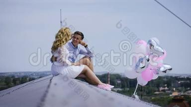 电影院。 年轻夫妇拿着气球坐在屋顶上