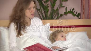 可爱的小女孩躺在床上，而母亲的女人<strong>读故事</strong>书