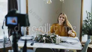 有魅力的、开朗的女人坐在餐桌前，在视频博客上<strong>录制</strong>关于<strong>相机</strong>上食物装饰设计的视频
