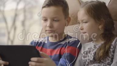 一个年轻的男孩和女孩乘公共汽车穿过<strong>城市</strong>，在电脑平板上<strong>看</strong>电影的特写<strong>镜头</strong>。