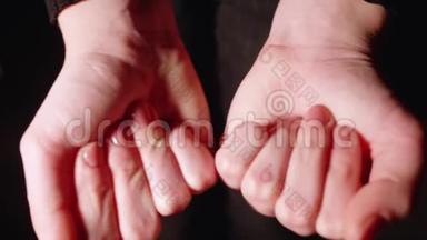 女人展示<strong>两个拳头</strong>，打开它们，展示张开的手掌中含有维生素。 黑色背景