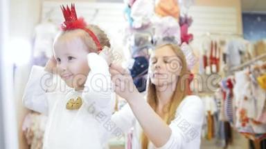 孩子们的服装店-金发小女孩和妈妈一起购物，买红帽子