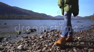 阿尔泰。 两个视频合一.. 露营妇女坐在山湖畔.. 穿着登山靴的女孩的脚