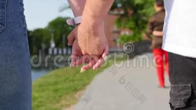 亲密的两个<strong>情人</strong>携手。 <strong>男女</strong>牵手在公园散步的细节剪影。 夫妇
