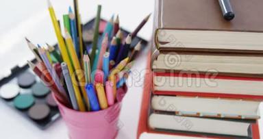 彩色铅笔放在笔筒里和一堆书