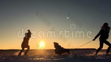 十几岁的<strong>女儿</strong>和母亲拉着小儿子在雪橇上跑。 剪影<strong>一家人</strong>在冬天玩。 积极健康