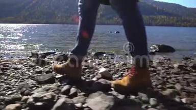 阿尔泰。 两个<strong>视频</strong>合一.. <strong>露营</strong>妇女坐在山湖畔.. 穿着登山靴的女孩的脚