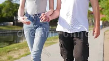 亲密的两个<strong>情人</strong>携手。 <strong>男女</strong>牵手在公园散步的细节剪影。 夫妇